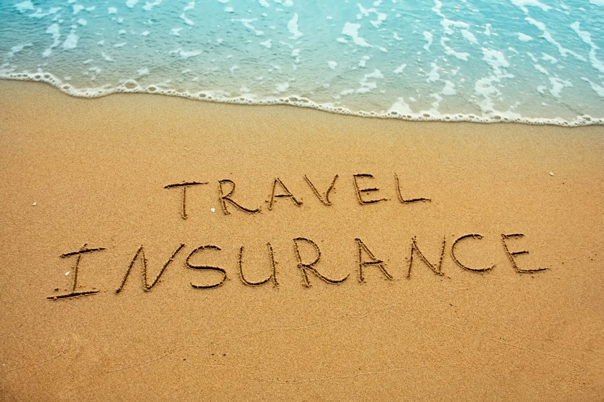 Travel insurance image in the sand