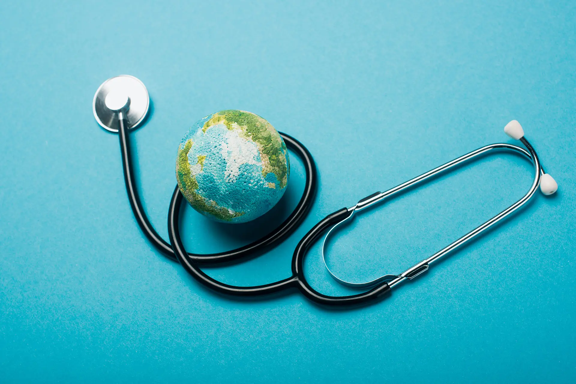 Globe and stethoscope on blue background, world health day