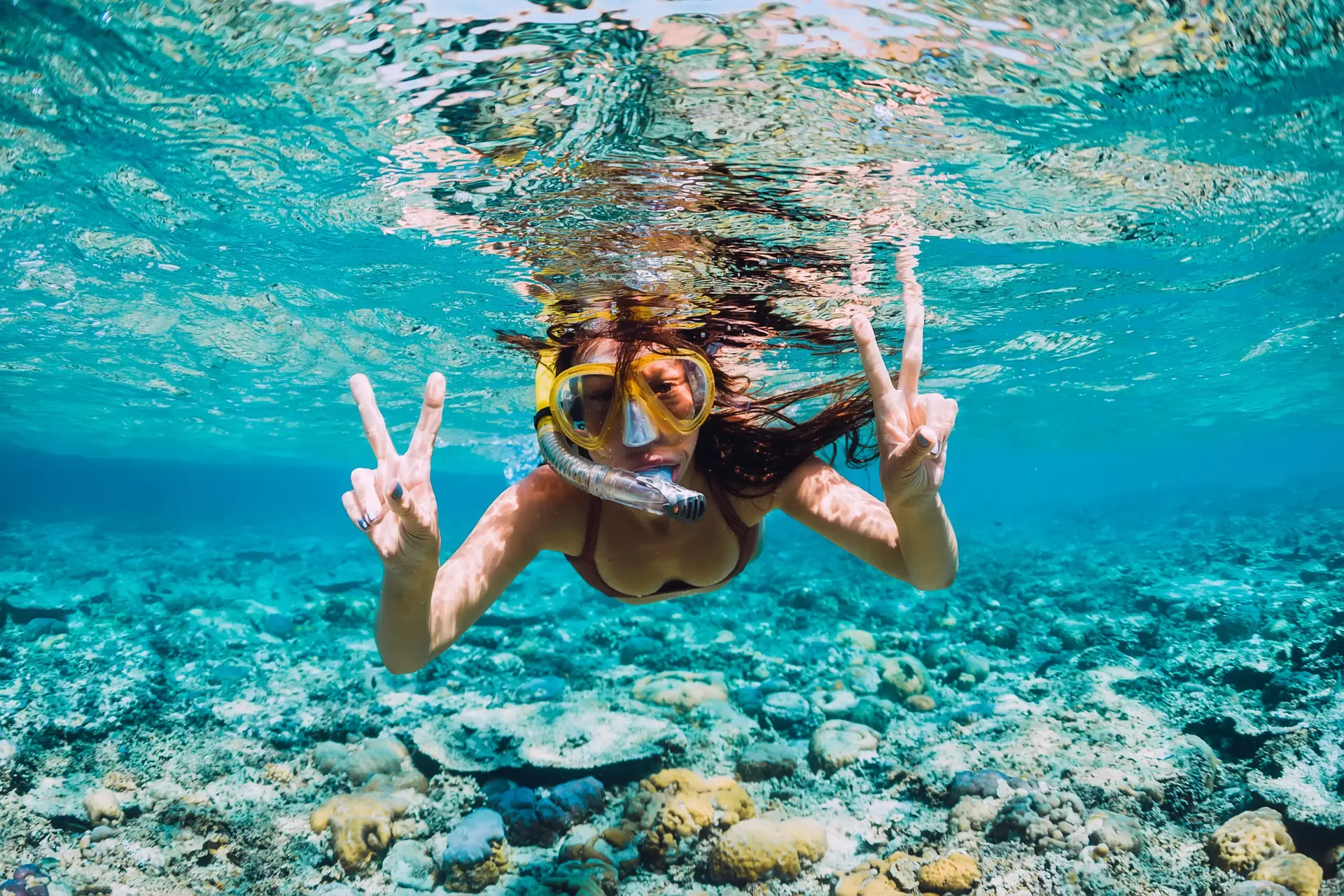 Young woman swimming underwater in clear tropical sea