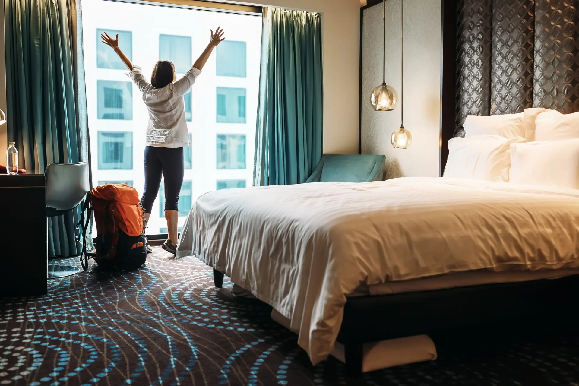 Solo female traveler stretching in modern hotel room