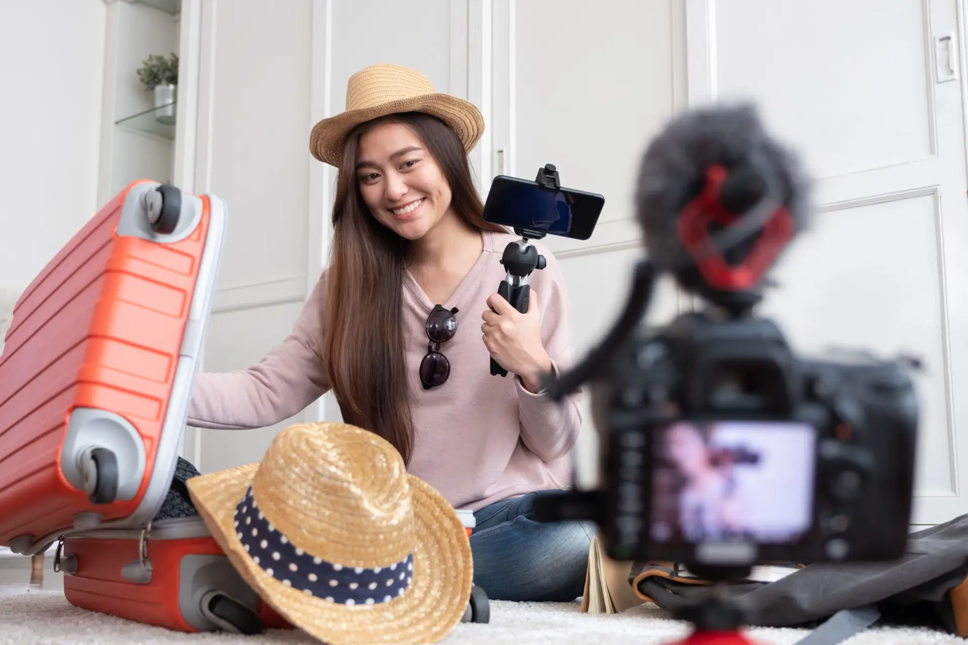 Asian female travel blogger filming vacation prep vlog at home