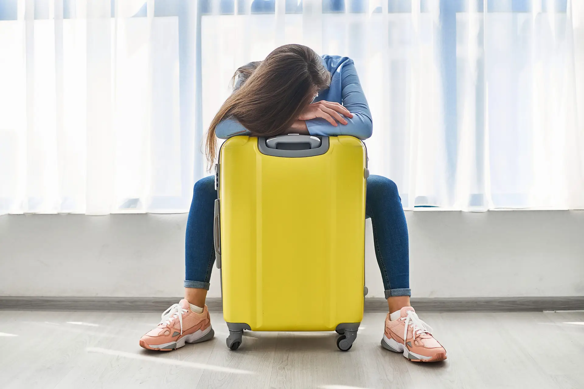 Woman traveler with yellow suitcase affected by flight