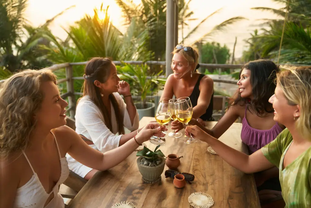 Happy women on girls trip enjoying wine and tropical vibes