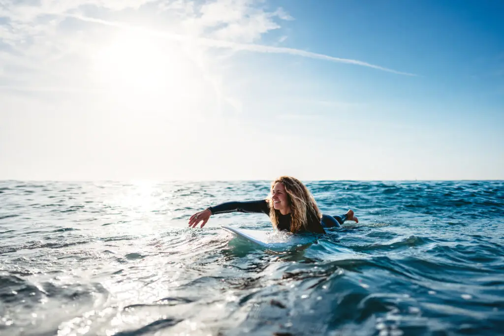 Woman surfing, Summer adventure water sports concept. Happy carefree woman surfing, living healthy active lifestyle
