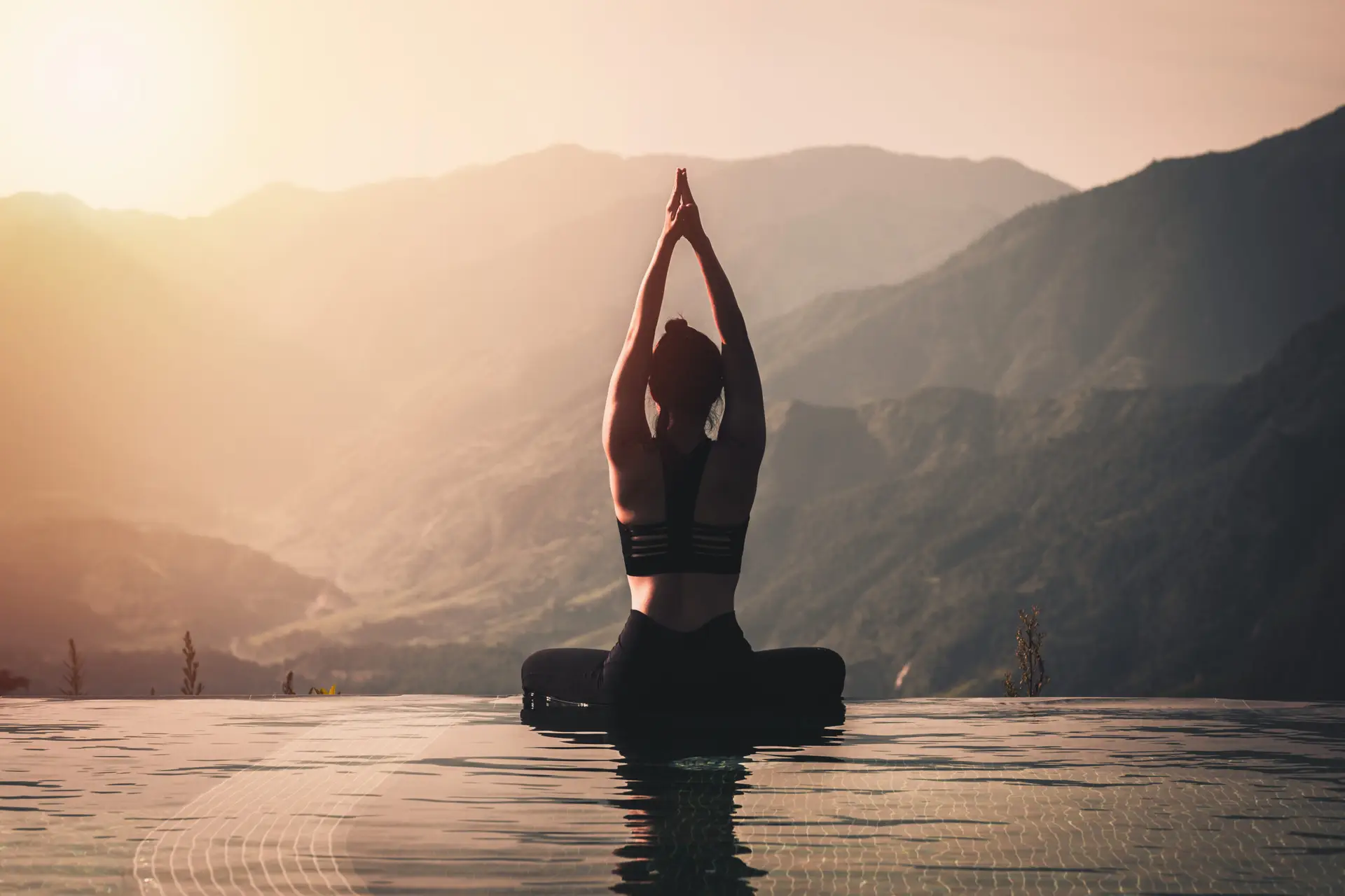 Relaxed woman meditating above scenic mountain view