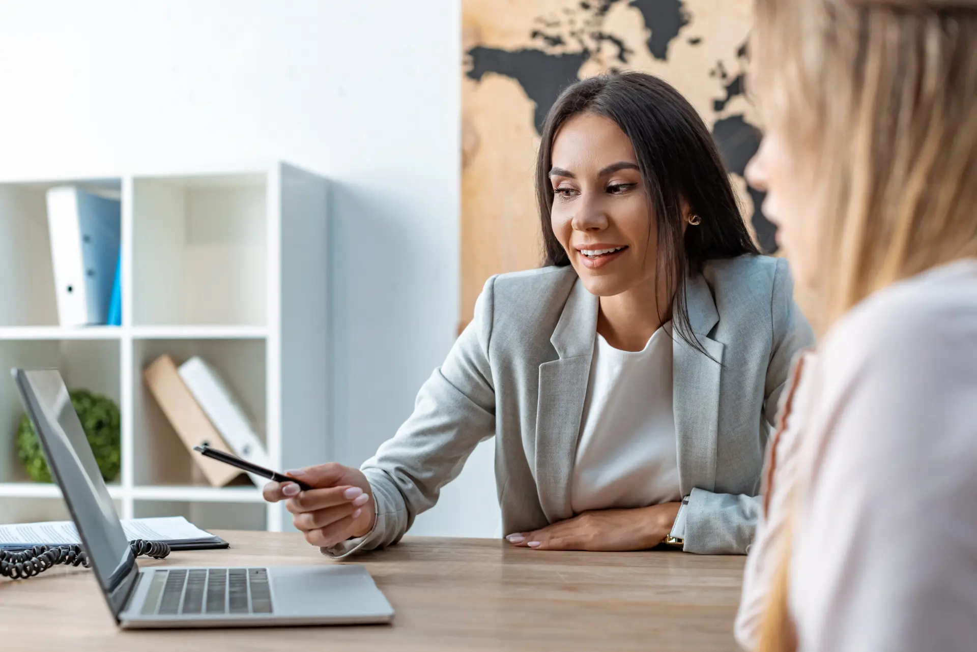 Travel agent showing trip plans on laptop to customer