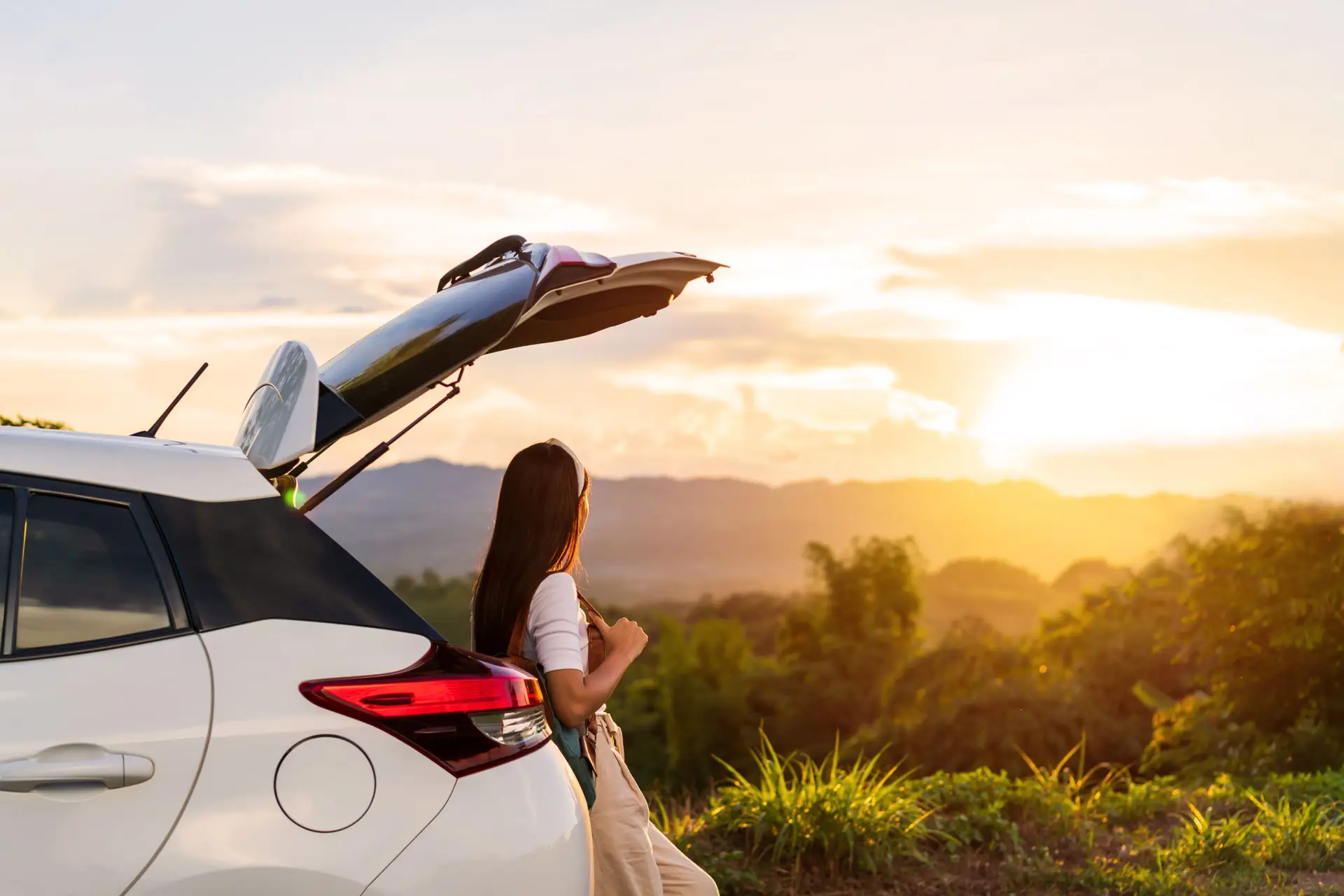 Young woman on road trip watching mountain sunrise