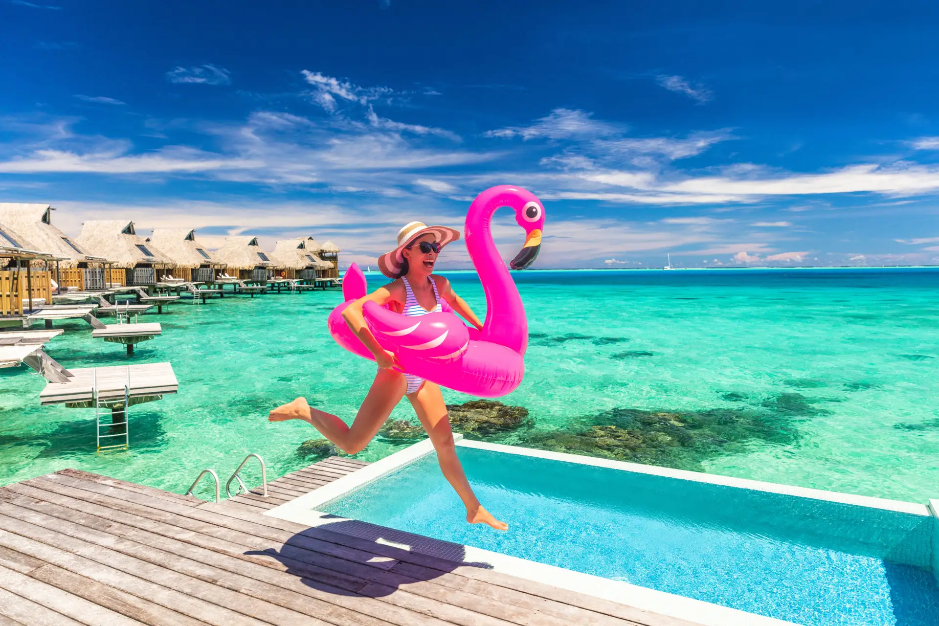 women jumping in pool on vacation