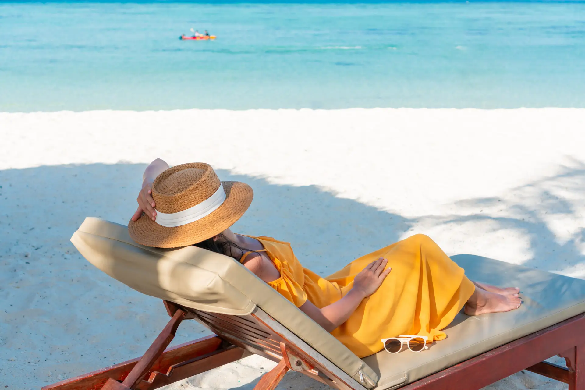 women laying out on the beach in a chair relaxing on a summer vacation