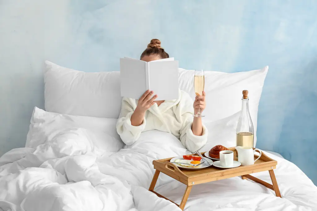 Mom relaxing in bed with a book and breakfast for Mother's Day